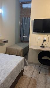 a bedroom with a desk with a tv and a chair at Hotel Villa Nature Br 153 in Hidrolândia