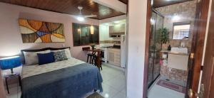 a bedroom with a bed and a small kitchen at Angel Ilha Flats e Varanda da Praia in Abraão