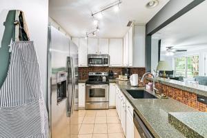 Una cocina con gabinetes blancos y un refrigerador de acero inoxidable. en half Mi to Bank of America Stadium Uptown Condo!, en Charlotte