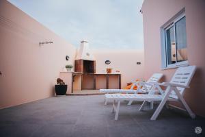 a room with two white chairs and a fireplace at Casa da Carreira in Almagreira