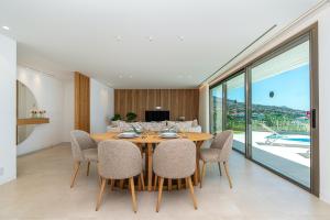 Un comedor con mesa y sillas de madera. en Villa das Neves by AnaLodges, en Estreito da Calheta