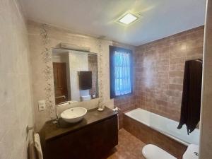 ein Badezimmer mit Waschbecken, Badewanne und Toilette in der Unterkunft La casa roja de Ovio in Picones