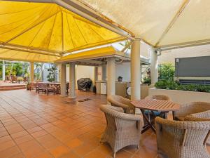 ゴールドコーストにあるModern 2Bed2BA, Heated Pool, BBQ, Balcony M27のパティオ(テーブル、椅子、大きなパラソル付)