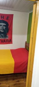 a room with a bed with a sign on the wall at Hotel Família Roots in São Thomé das Letras