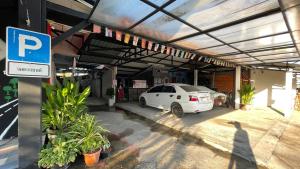 a white car parked in a parking lot at At Home สระบุรี in Sara Buri