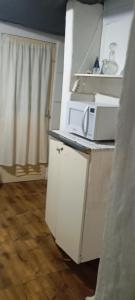 a kitchen with a microwave on top of a counter at Hotel Família Roots in São Thomé das Letras +5 photos