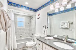 a bathroom with a sink and a tub and a toilet at Beach Please in St Pete Beach +32 photos