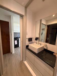 a bathroom with a sink and a large mirror at Apartmento completo en Nueva Córdoba Argentina in Cordoba