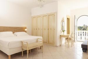 a white bedroom with a bed and a chair at Fiordaliso Hotel in San Felice Circeo +18 photos
