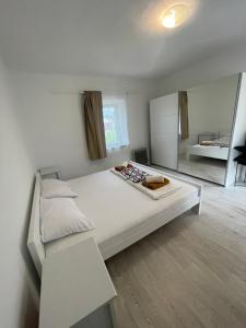 a bedroom with a large white bed and a mirror at Holiday Home in Trebinje