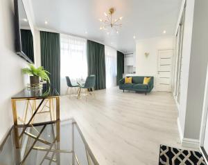 a living room with a green couch and a table at Luxury Emerald Apartments in Irpin