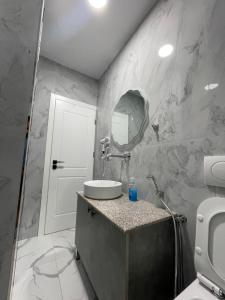 a bathroom with a sink and a mirror at Azzurro Boutique Apartaments in Sarandë +32 photos