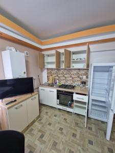 a kitchen with white cabinets and a stove top oven at Apartament in vila in Paşcani