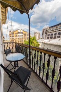 a balcony with a table and chairs and buildings at DayFlat Apartments in Kyiv