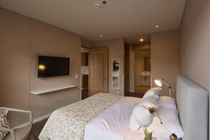 a bedroom with a bed and a tv on the wall at Spacious Apartment with Balcony in Chía in Estación El Salto