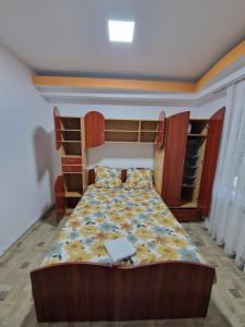 a bedroom with a bed with a wooden head board at Apartament in vila in Paşcani +5 photos