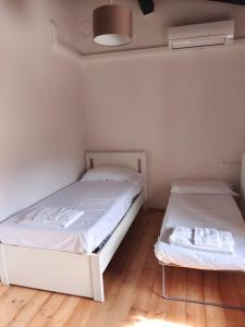 two beds in a room with white walls and wooden floors at Appartamento Farnia a 3km da Garda in Castion Veronese +29 photos
