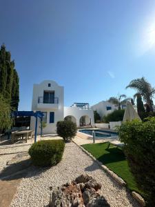 a villa with a swimming pool and a house at LATCHI RIVIERA THALASSA Villa in Neo Chorio