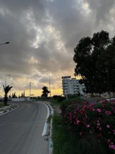 eine leere Straße mit Blumen am Straßenrand in der Unterkunft Kantoui apartment in Kasnadar