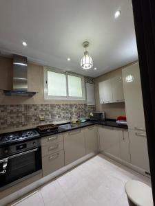 eine Küche mit weißen Schränken und einem Herd in der Unterkunft Kantoui apartment in Kasnadar