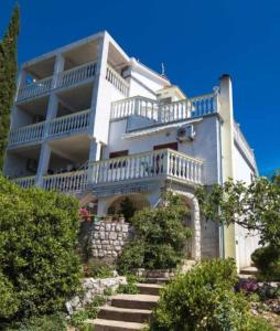 a large white building with stairs in front of it at Apartmani Štefica in Dramalj
