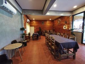 a dining room with a table and chairs and a couch at บ้านพักมิตรภาพโฮมสเตย์ in Ban Choko