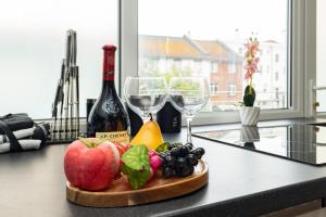 a plate of fruit and wine glasses on a counter at Open Mind Property -8 Guests, 4Beds & Free Parking in Hayling Island +26 photos