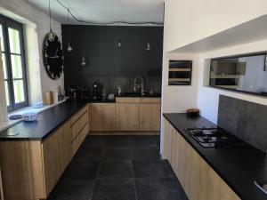 a kitchen with black counter tops and wooden cabinets at Chez Marine & Justine in Charolles
