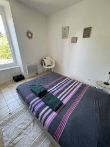 a large bed in a room with a window at Maison au calme , proche du parc du PDF in Pouzauges