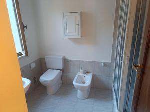 a bathroom with a toilet and a sink at angelhouse1 in Pozzomaggiore