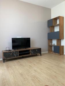Cozy Apartment For Daily Rent في تبليسي: غرفة معيشة مع تلفزيون بشاشة مسطحة في مركز ترفيهي