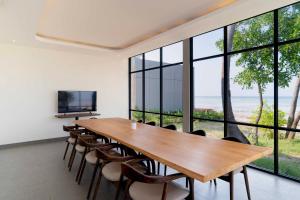 Pulau Tidung-besarにあるNirva Ocean Houseの大きな木製のテーブルと椅子のあるダイニングルーム