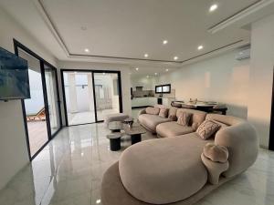 a large living room with a couch and a table at Magnifique Villa Kayo, Djerba in Arkou