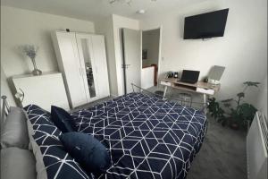 a bedroom with a blue and white bed and a desk at 1 Bed-Sleeps 4-Garden-Free Parking in Didcot