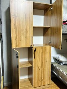 a wooden cabinet with shelves in a room at Cosiness Hostel in Osh