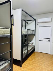 a room with three bunk beds and a door at Cosiness Hostel in Osh