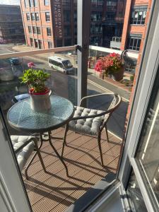 a table and chairs on a balcony with a window at Lovely 1 bedroom top floor flat at Chocolate Quarter near city of Bath in Keynsham