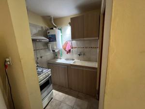 a small kitchen with a sink and a stove at Las Margaritas in Pila +13 photos