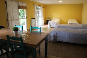 a room with two beds and a table and chairs at Las Margaritas in Pila