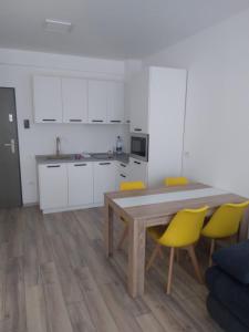 una cucina con tavolo in legno e sedie gialle di Studio Andrei a Baile Felix