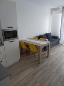 un soggiorno con tavolo e sedie gialle di Studio Andrei a Baile Felix