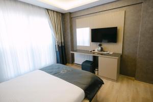 a hotel room with a bed and a flat screen tv at stay on hotel in İzmir