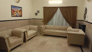 een wachtkamer met 2 banken en een open haard bij Royal one cottage in Islamabad