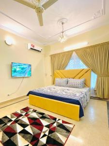 een slaapkamer met een geel bed en een raam bij Royal one cottage in Islamabad