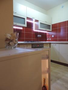 a kitchen with red tiles on the wall at Apartament Violet in Krosno