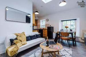 a living room with a couch and a table with a laptop at 2 Bedroom Top Floor Apartment that Sleeps 4 in Birkenhead