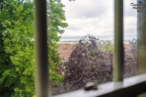 a window with a view of trees and buildings at 2 Bedroom Top Floor Apartment that Sleeps 4 in Birkenhead