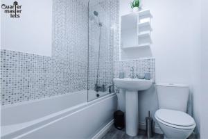 a white bathroom with a toilet and a sink at 2 Bedroom Top Floor Apartment that Sleeps 4 in Birkenhead +18 photos