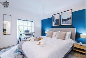 a bedroom with a large white bed with blue walls at 2 Bedroom Top Floor Apartment that Sleeps 4 in Birkenhead