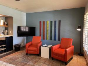 a waiting room with two chairs and a flat screen tv at Desert Paradise - A Men's Clothing Optional Resort in Palm Springs